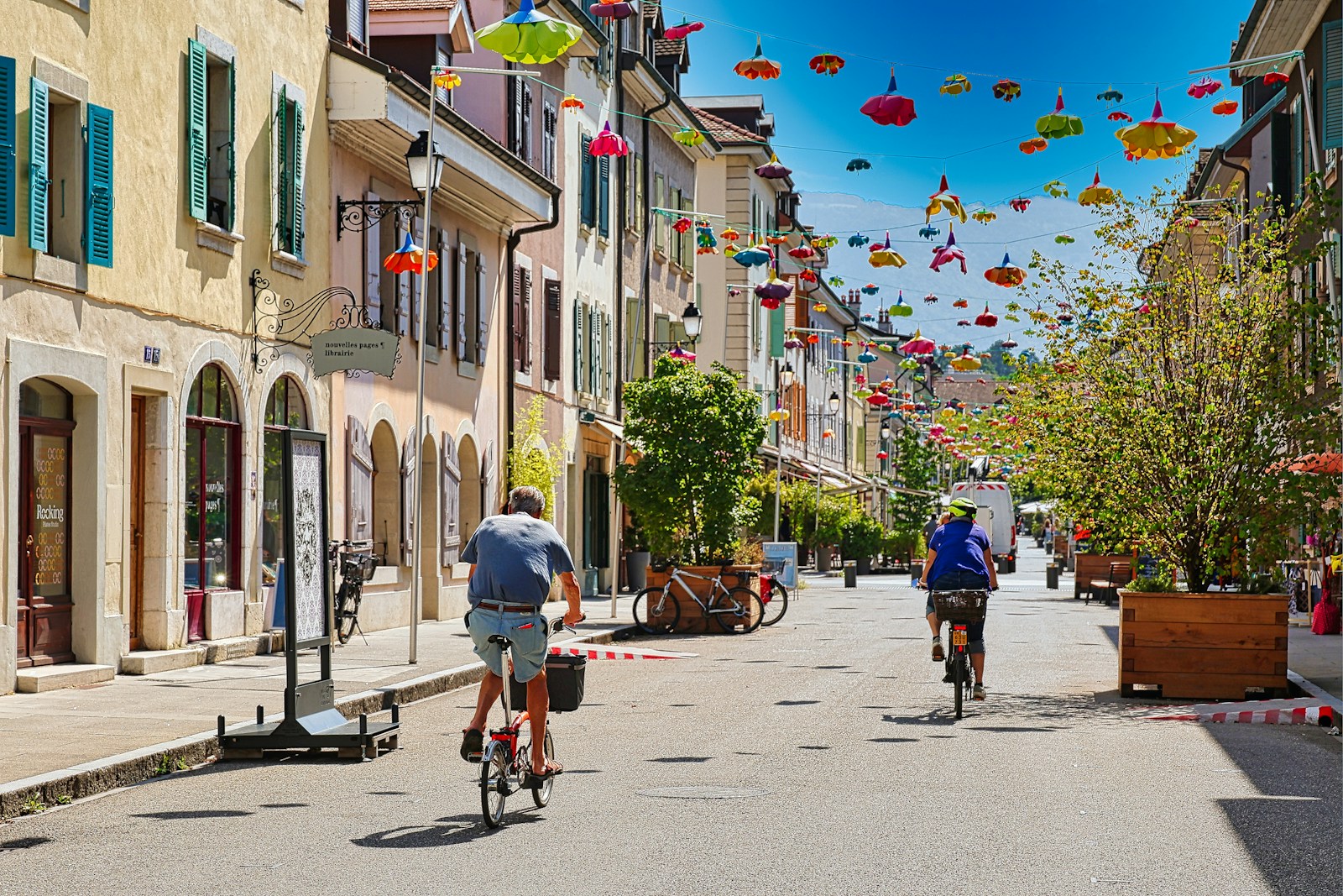 A couple of people riding bikes down a street